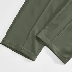 Gros plan détaillé montrant les revers d'un pantalon de costume pour homme vert olive ajusté