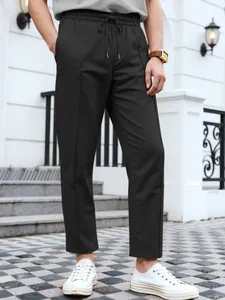Slim-fit black men's business casual trousers with drawstring waist and twill fabric.