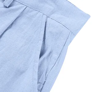 Vista dettagliata della tasca di un pantalone in lino azzurro che mostra la trama