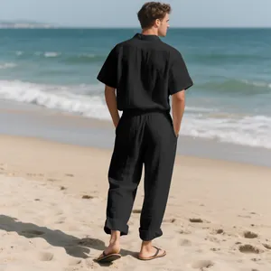 Vista trasera de un hombre con un conjunto de camisa y pantalón de lino negro en la playa