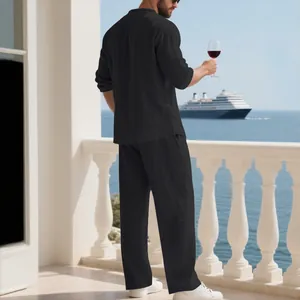 Uomo in completo di lino nero da vacanza su balcone con vista su nave da crociera e mare