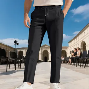 Vista detallada de pantalones de traje negros con cordón sobre un modelo masculino