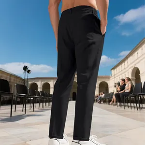 Vista detallada de pantalones de negocios negros de pierna recta en un modelo en una plaza.