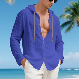 Detail view of men's blue loose linen hooded casual shirt in a sunny beach setting