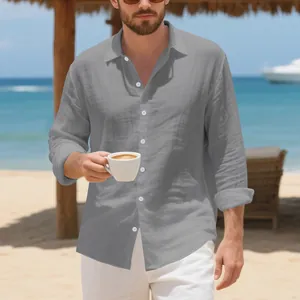 Detail van grijs linnen herenoverhemd in een casual strandsetting met kopje koffie.