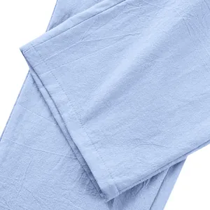 Dettaglio macro del tessuto in lino azzurro e della cucitura dell'orlo dei pantaloni