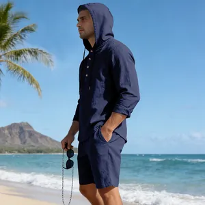 Zijaanzicht van een man die een marineblauwe linnen strandset met capuchon draagt