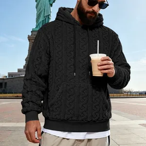Gros plan détaillé du motif torsadé sur le sweat à capuche en polaire noire pour homme