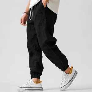 Detail view of men's black linen cotton joggers with elasticated cuffs and drawstring waist.