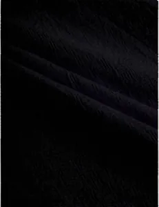 Close-up detail of black breathable cotton linen fabric texture for men's jogger pants