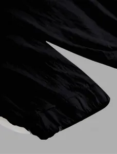 Close-up macro detail of breathable black linen fabric texture on men's jogger pants