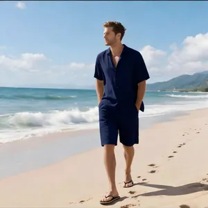 Mann am Strand im navyblauen Set aus kurzärmeligem Leinenhemd und passender Shorts