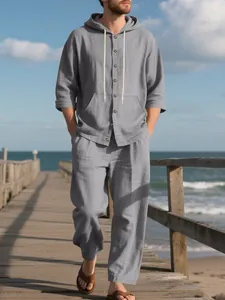 Heren tweedelige grijze linnen strandset met hoodie shirt en losse broek op steiger