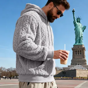 Profil latéral d'un homme portant un sweat à capuche gris en polaire teddy à texture jacquard.