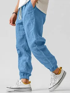 Close-up of men's light blue breathable linen jogger pants with elasticated cuffs.