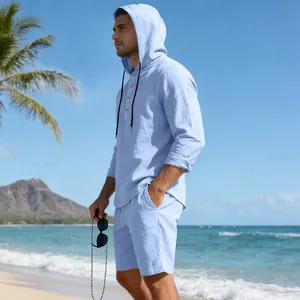 Zij-aanzicht van een lichtblauwe linnen set met hoodie en short op het strand