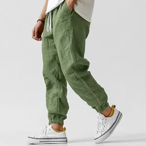 Side view of men's green linen joggers featuring elastic cuffed ankles and breathable fabric.