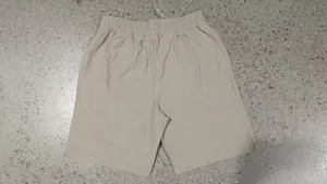 Detailed back view of men's casual beige linen shorts featuring elastic drawstring waistband
