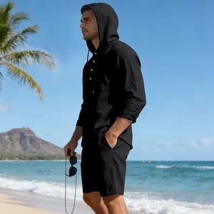 Heren zwarte linnen set met hoodie shirt en korte broek, gedragen op een zonnig strand