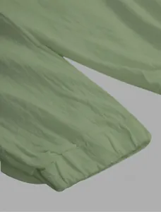 Detail shot of sage green linen blend jogger pants showing elasticized cuff texture