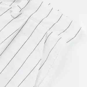 Close-up of white linen fabric with thin black vertical stripes for casual men's trousers