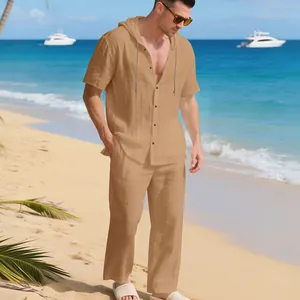Vollansicht des Herren-Leinensets mit Kapuzenhemd und Hose in entspannter Strandkulisse