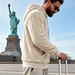 Vue détaillée d'un sweat à capuche en polaire beige à motifs torsadés pour hommes en extérieur.