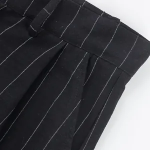 Close-up detail of black linen trousers with white pinstripes showing waist and pocket