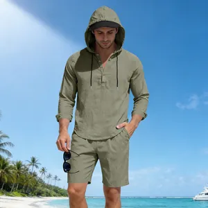 Linnen herenset met hoodie en korte broek, gepresenteerd op een tropisch strand.