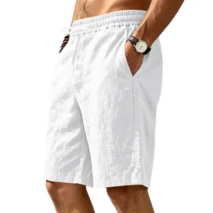 Detailed view of white men's linen beach shorts with drawstring waist and pockets.