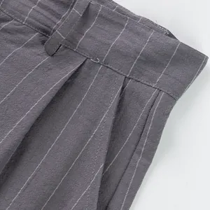 Detail shot of men's grey striped linen trousers showing waistband and side pocket.