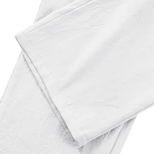 Primo piano dell'orlo dei pantaloni di lino bianco che mostra trama e cuciture naturali.