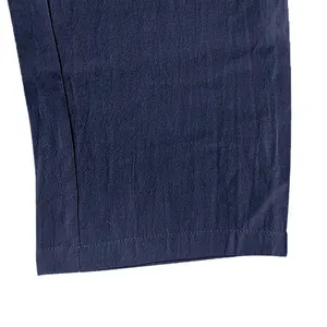 Close-up of navy blue linen pants hem showing breathable texture and stitching detail.