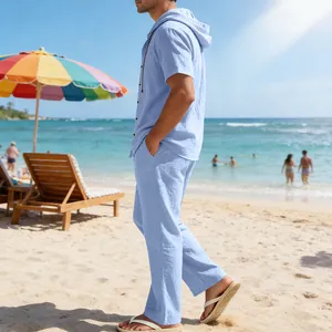 Detailansicht der hellblauen Leinen-Kombination mit Kapuzenshirt und Hose am Strand