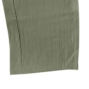 Close-up of linen fabric texture and hem stitching on olive green cargo pants