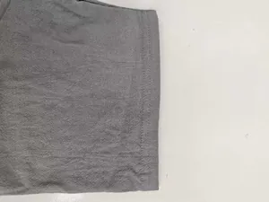 Gros plan de la manche d'une chemise en lin gris montrant les doubles coutures