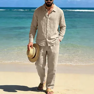 Full view of men's casual linen outfit set on a beach with long shirt and trousers