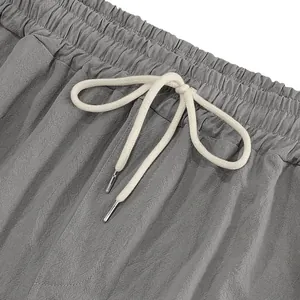 Macro detail of the elastic waistband with white drawstring on men's gray linen pants