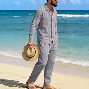 Man wearing a casual grey linen shirt and matching pants set on a sunny beach background