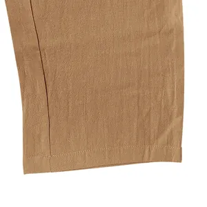 Close-up detail of men's khaki linen trousers showing hem stitching and fabric texture