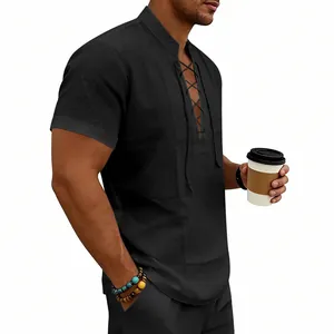Uomo in camicia Henley di lino nero con lacci che tiene una tazza di caffè