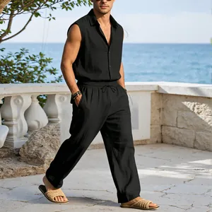 Male model wearing black sleeveless linen shirt and pants set on a sunny balcony by the sea