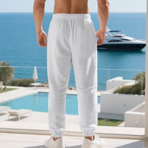 Back view of men's white breathable cotton linen joggers in a luxury seaside balcony setting