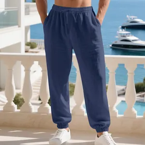 Detailed view of dark blue linen joggers with drawstring waist and elastic cuffs.