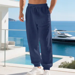 Detail of men's navy blue linen jogger pants featuring drawstring waist and elastic cuffs