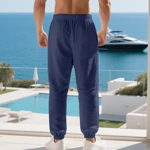 Back view of men's navy blue linen joggers on a luxury balcony with sea view