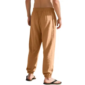 Back view of men's loose linen pants showing tapered ankle cuffs and fabric texture