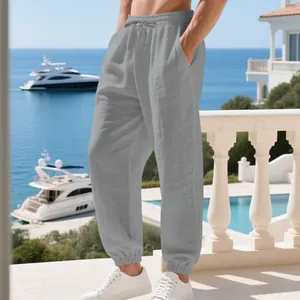 Casual grey linen joggers for men with drawstring waist in a Mediterranean beach setting