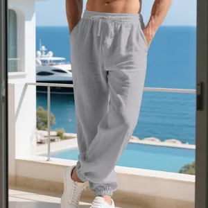Close-up view of grey breathable cotton linen joggers for men on a sunny beach balcony
