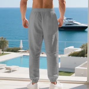 Rear view of men's breathable gray linen jogger pants in a luxury beach setting